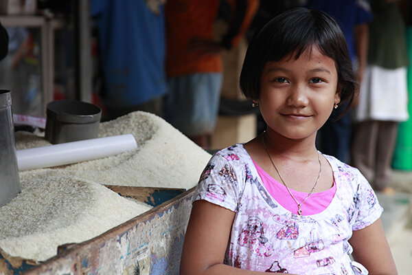A young girl shopping with her mother at a local market in Jakarta, Indonesia (2011)